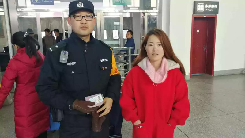 图为民警为旅客寻找遗失卡包