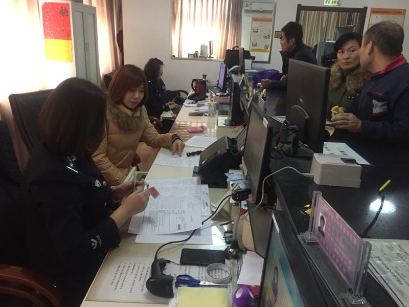 图一，记者在办证大厅体验户籍民警工作