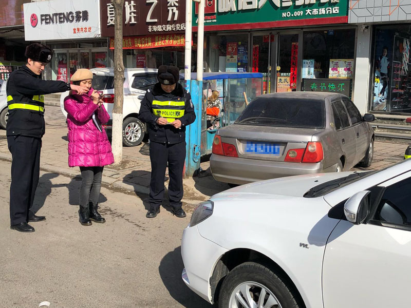 记者随交警在街边给违停车辆拍照