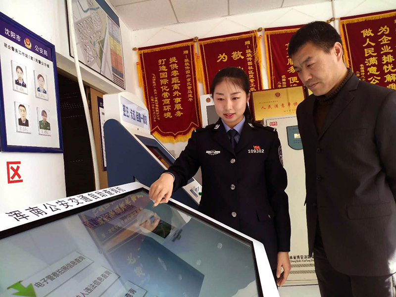 王凯迪（左）演示自助机操作方法