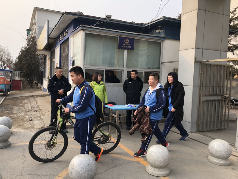 （图三）记者在校门口站岗，守卫校园安全
