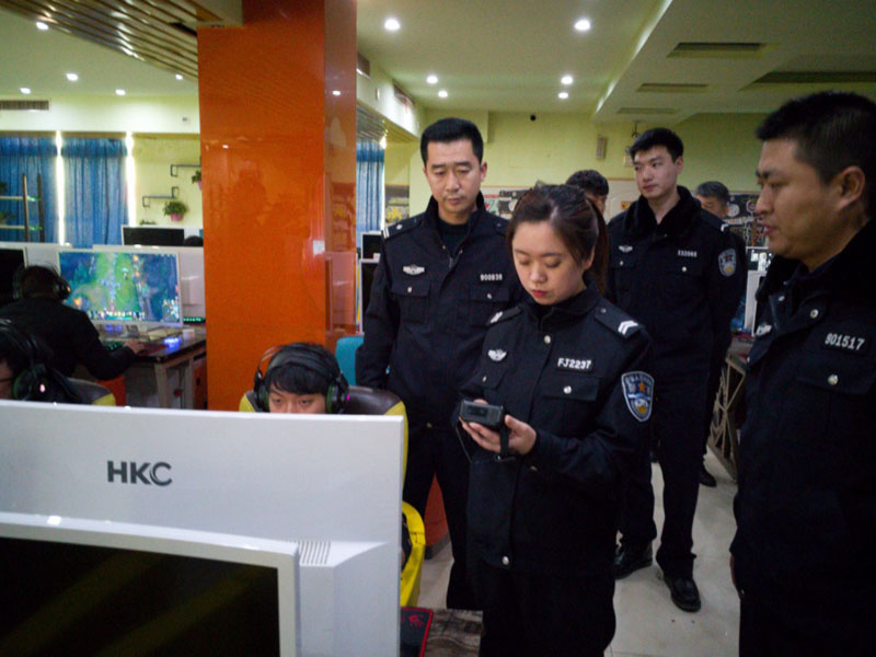 图四：记者（前排右二）同民警一起到网吧进行身份证检查