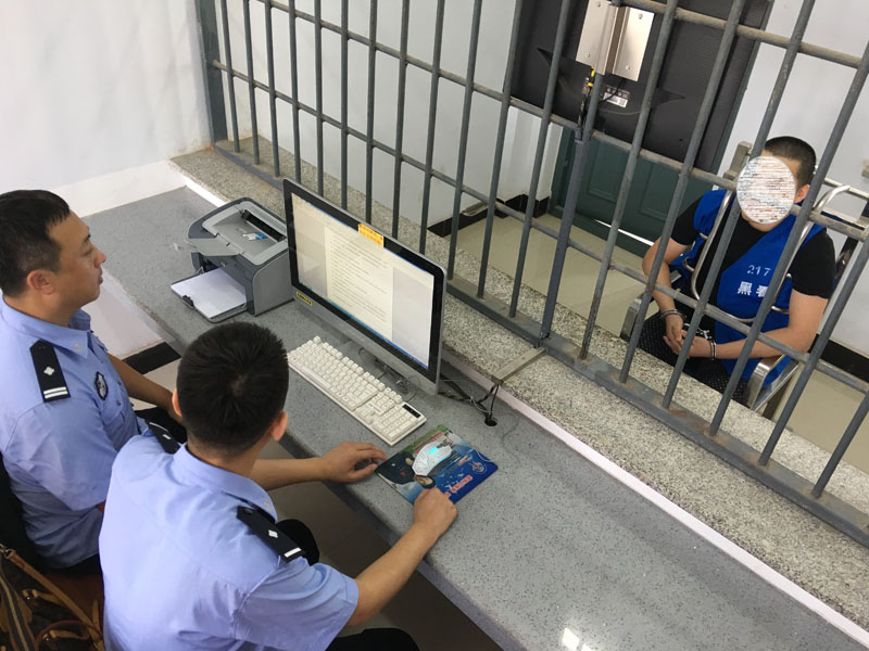 图二：民警正在讯问犯罪嫌疑人周某