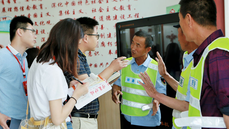 采访团成员同护路队员交谈