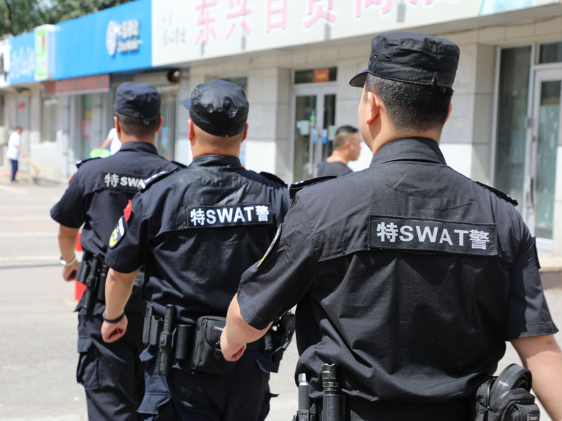 烈日下，巡特警队员身上的汗水浸湿了警服