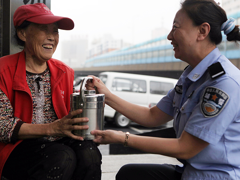 几年这个爱心团队的女警们每天坚持为大厅门口卖报摊的金大娘送“爱心午餐”