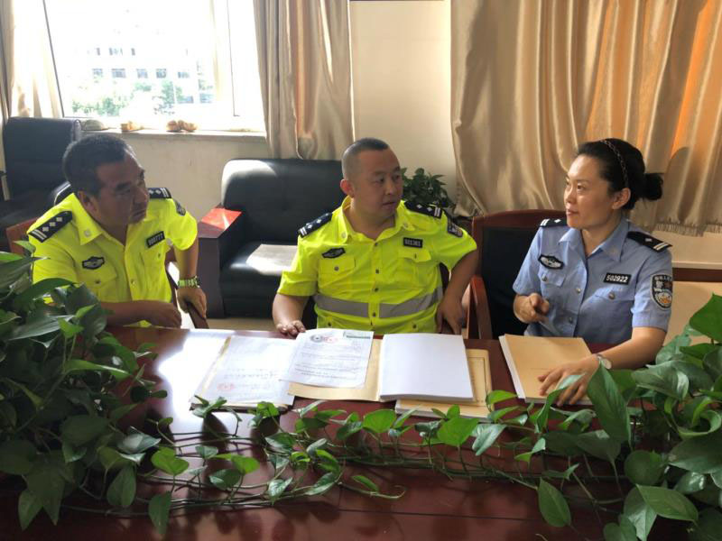 本溪市公安局交警支队交通事故大队办案民警和本溪市公安局预审支队二大队教导员孟媛媛一起讨论案件