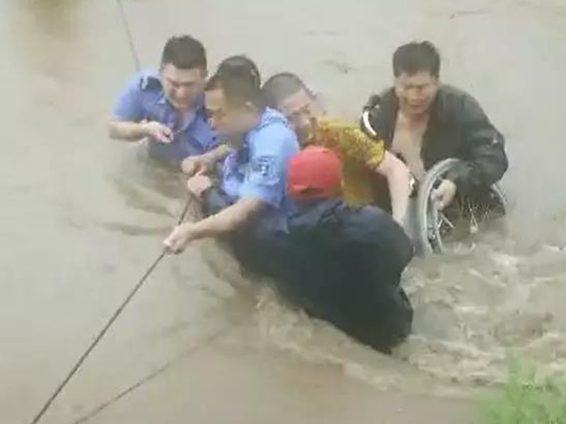 瘫痪村民（黄衣）在被救上岸前露出笑容