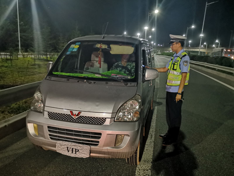 交警正在查处酒驾并故意遮挡号牌的驾驶员孟某