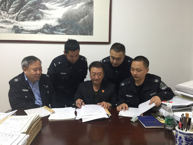 张福江（中）和同事们一起研究案情