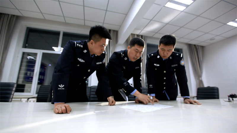 于恩龙(左二)正在和同事研究嫌疑车辆轨迹