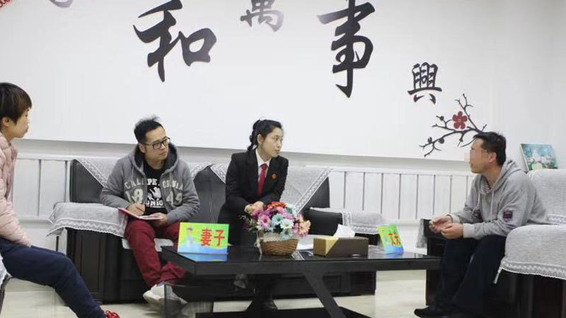记者（左二）与法官张杨在家事调解室中开导夫妻二人
