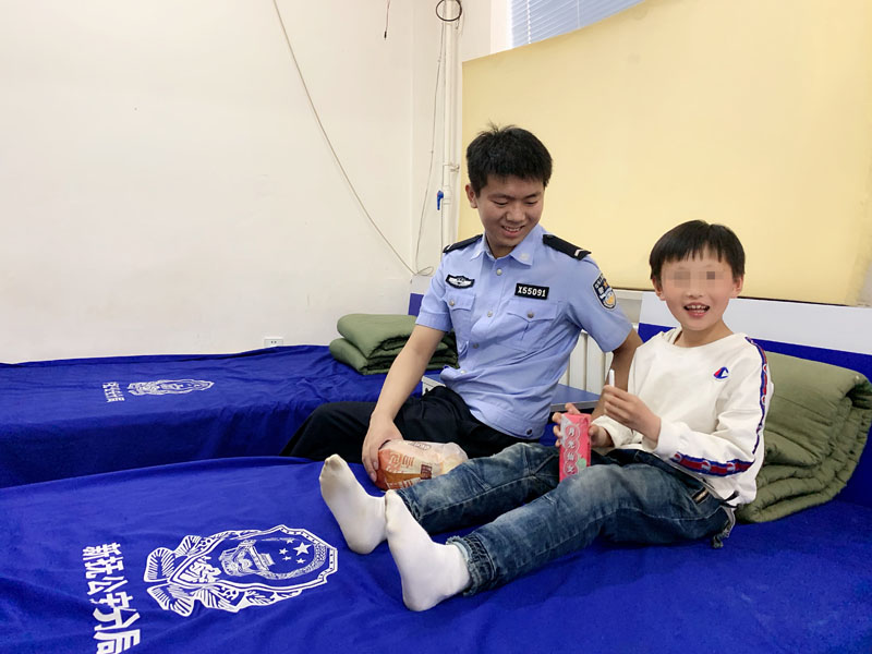 派出所民警正陪着孩子边吃东西边看动画片