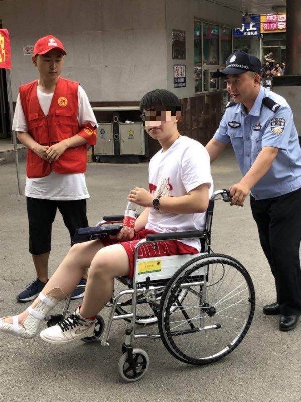 大东公安分局执勤民警与平安志愿者对脚部骨折考生出入考场提供全程护送服务