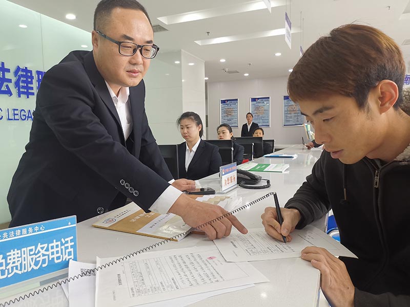 中心法援窗口工作人员指导市民填写法援申请表