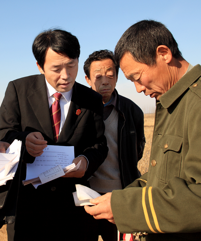 苗长阔（左二）在田间地头为农民解决纠纷