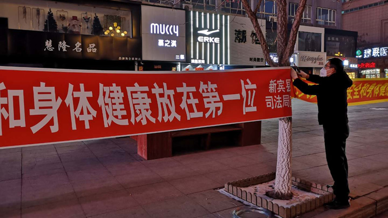 战艳国在寒风中悬挂宣传条幅