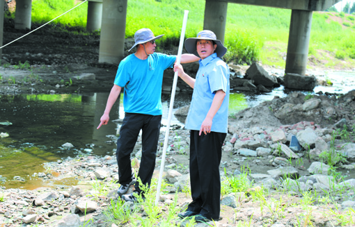 配文1：朱闯（左）跟同事们对“母亲河”进行实地取样