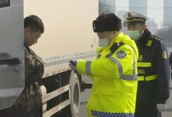 联合执法队队员正在查看货车驾驶员的证件