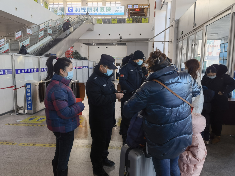 记者（左一）在盘锦中进站口采访