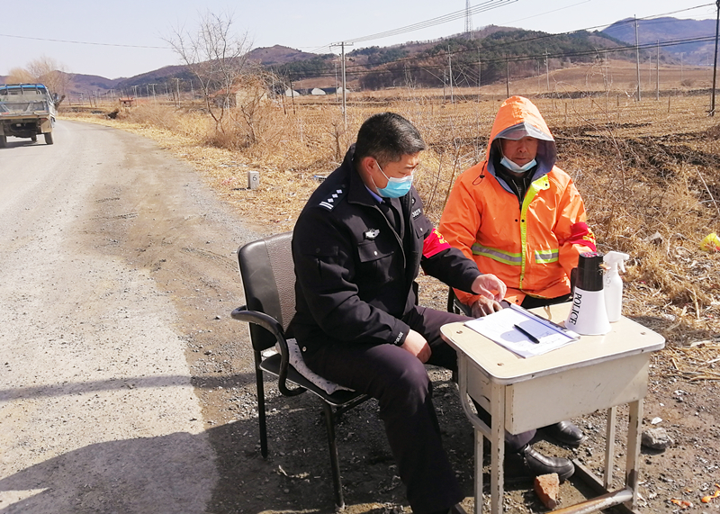 李凤伟（左）和村民在村口值守中