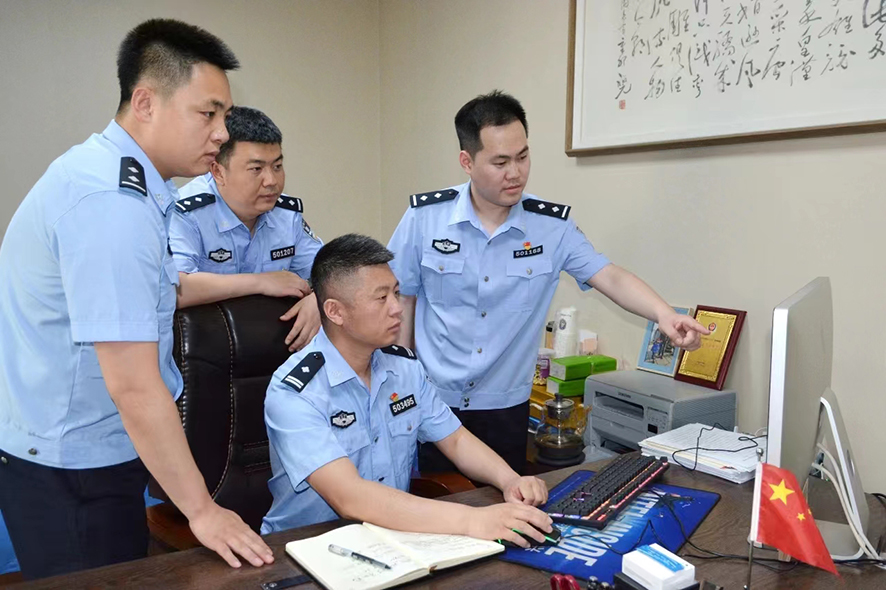 郑群（右二）正在和同事研究案件