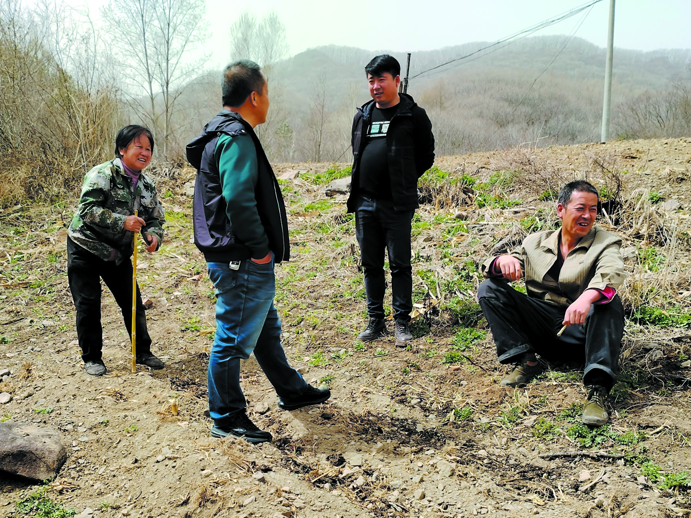 二棚甸子镇四道岭子村网格员刘利伟（右二）在地头调解矛盾纠纷