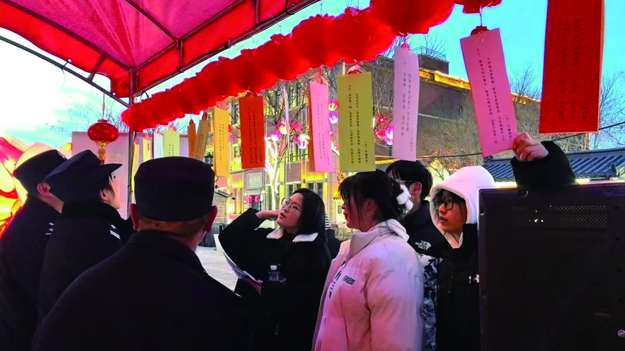 群众在反诈小铺猜谜