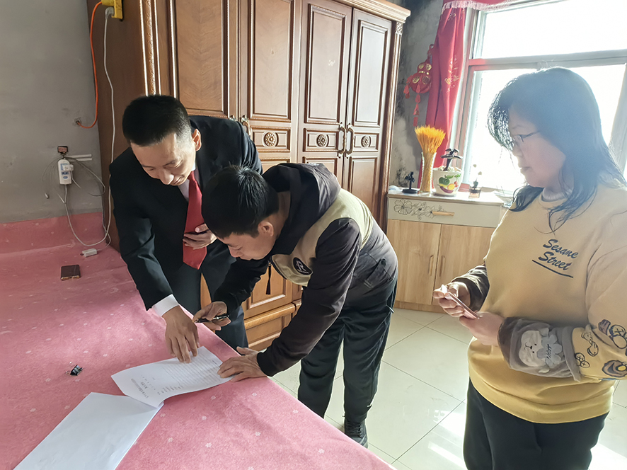 徐晓东（左一）指导孟某（中）在结案书上签字