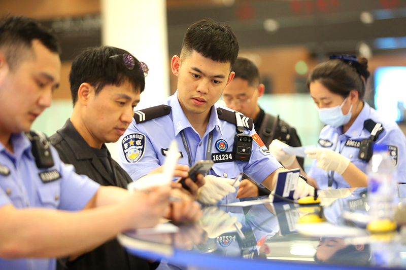 民警协助外国旅客填写入境卡片。