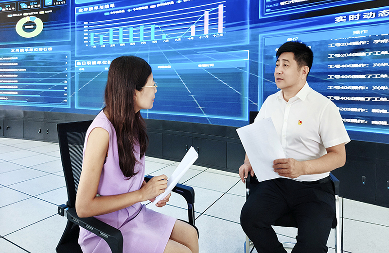 于洪刚（右）接受记者采访