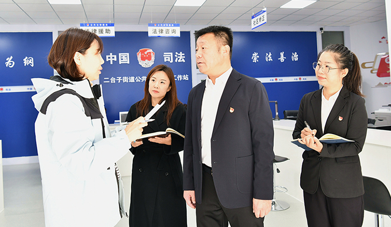 大东区司法局党组书记、局长安宏阳（左三）向记者介绍司法所工作情况