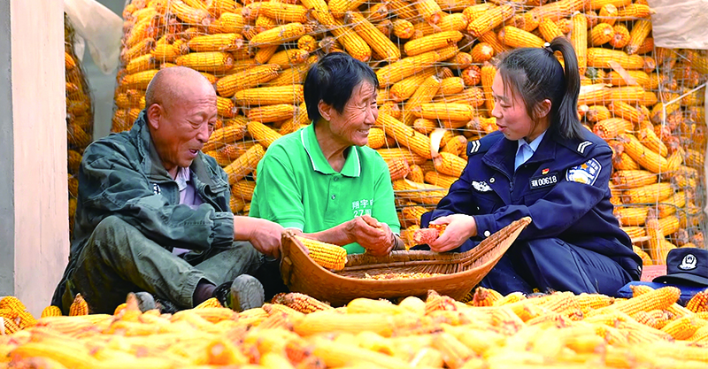 驻村辅警帮助群众秋收唠家常