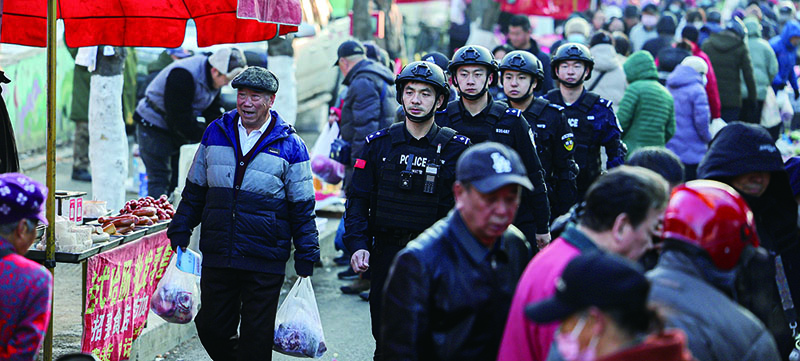 铁岭市公安局巡特警支队民警在银州区驻跸园早市开展巡逻(李松摄)