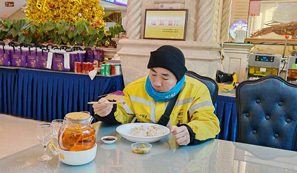 网约配送员小于大口大口吃着饺子