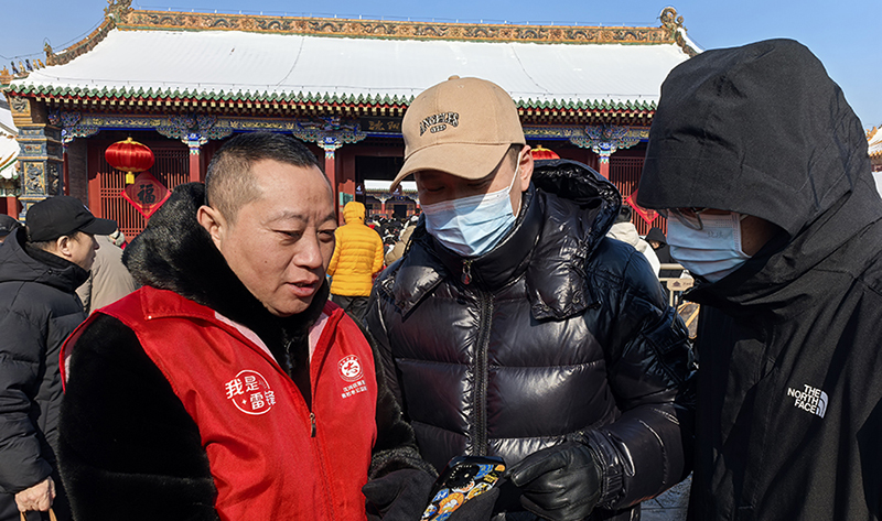 沈阳市善若水公益服务中心理事长高聪（左）为游客指路