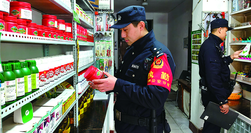 铁岭市公安局铜钟分局治安民警在农资商店检查核对农药经营资质、质量、储存、有效期等情况。