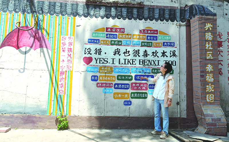 杨轶达向记者介绍社区的墙绘。
