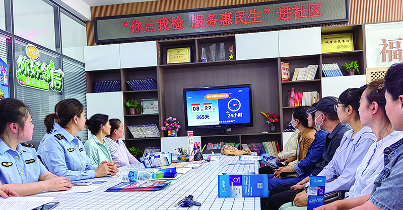 社区居民在观看“你点我检”活动宣传视频