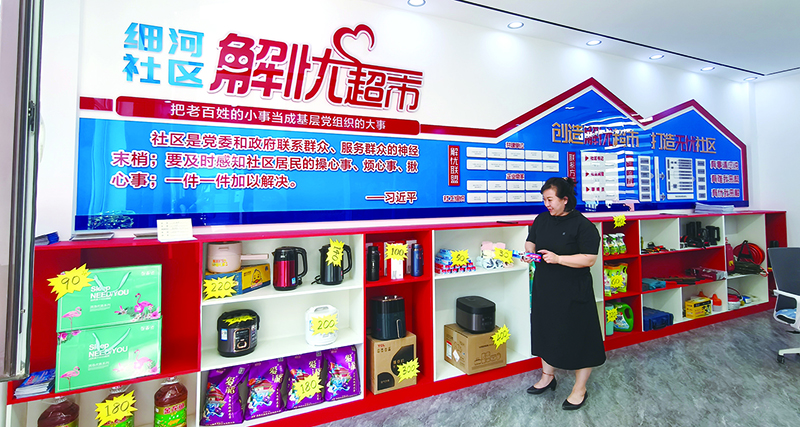 头题图，社区书记孙云向记者介绍”解忧超市”里的奖品。