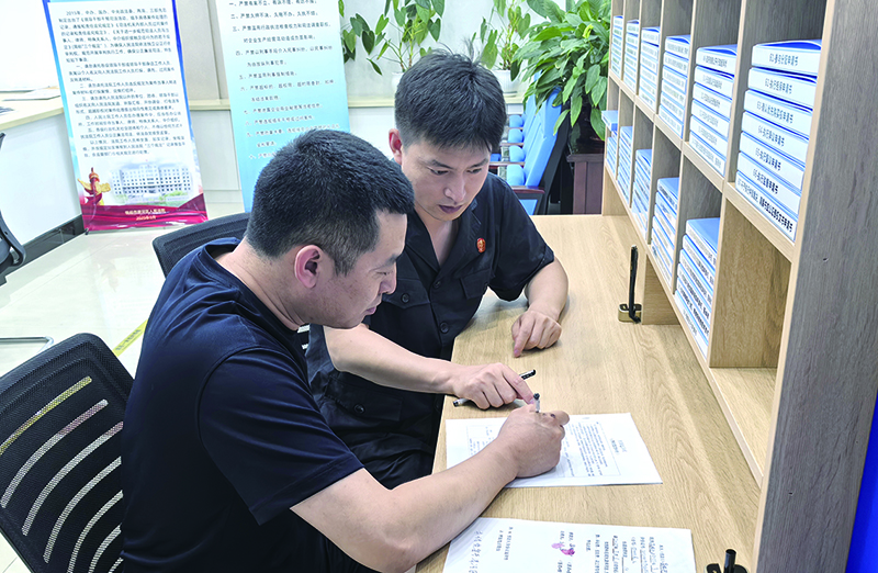头题图，导诉员佟浩正在指导刘某填写要素式起诉状