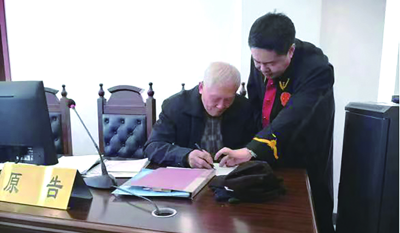 吕晋锋（右一）指导当事人填写法律文书