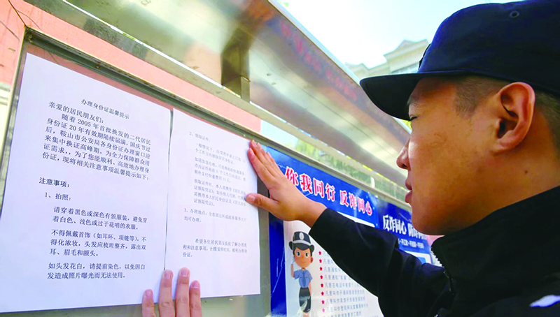 民警在社区公告板上张贴“大字版换证指南”