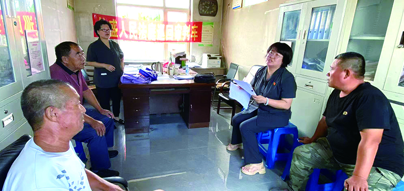 刘芳庭长（右二）在八一红菱街道某村讲解土地承包相关法律法规