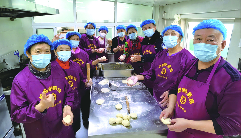 “妈妈厨房”志愿者们在后厨包包子场景