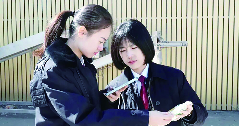 检察官在扫描农产品包装袋上的二维码，查看生产地等信息。