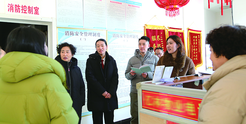 记者跟随赵洋（左三）法官走访，在物业服务中心向业主了解近况