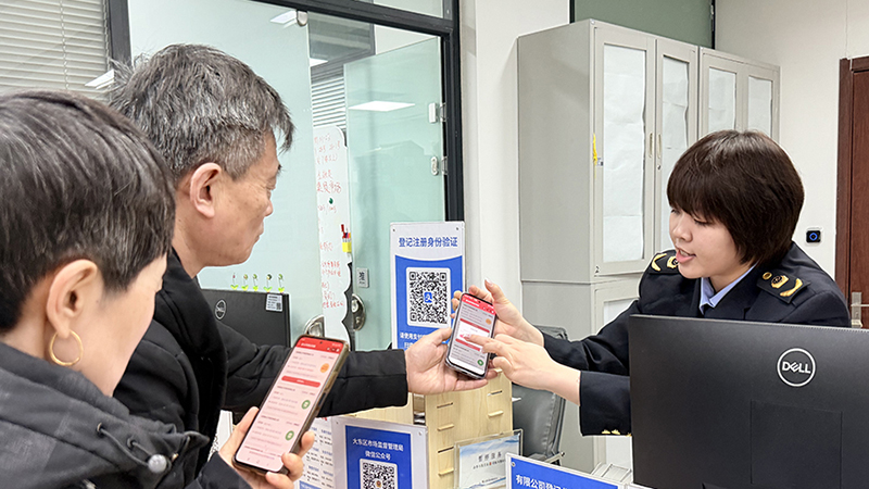 头题图，窗口工作人员指导申请人进行支付宝实名认证