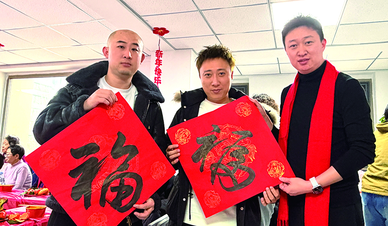 新就业群体和社区书记（右一）展示“福”字