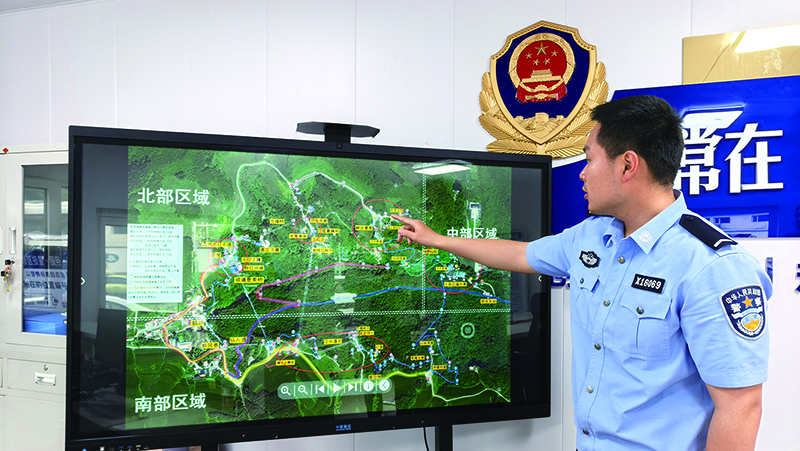 民警李宇在警务室大屏幕前向记者介绍景区监控和报警点位牌分布情况 本报记者刘妍 摄